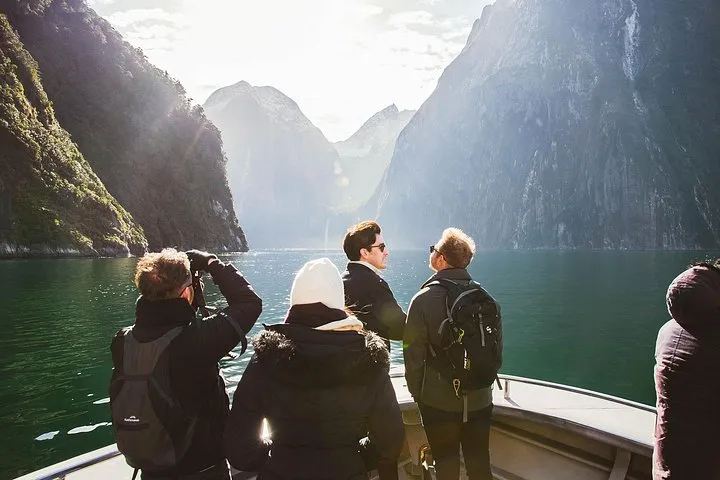 Small group tour van beside a lake on the Milford Road to a Milford Sound boat tour from Queenstown