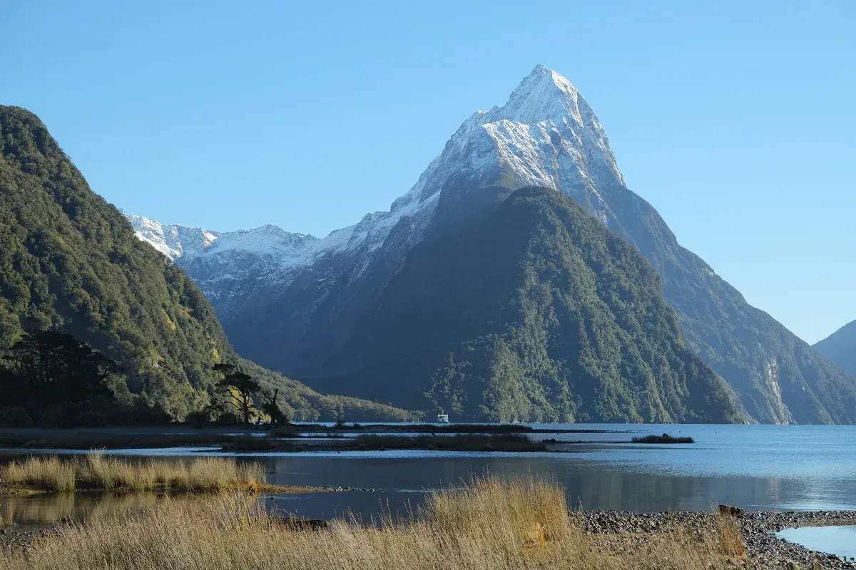 Snow-covered Mitre Peak seen from the foreshore on a clear winter day, the landmark of every Milford Sound cruise
