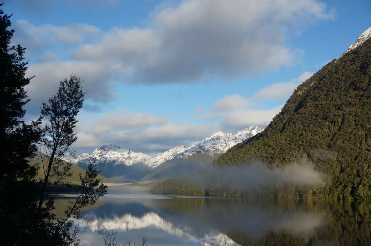 Lake Gunn reflecting mountains beside the road to a Milford Sound cruise